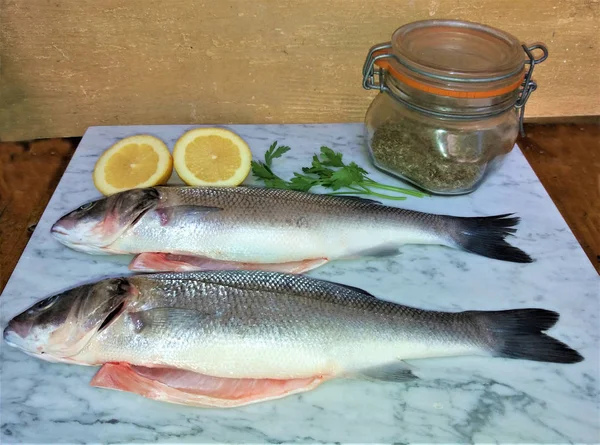 Peixe fresco com limão e especiarias em mármore — Fotografia de Stock