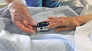 Sıhhiye ve hasta parmak nabız oksimetresi kullanıyor. 