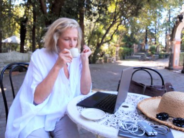 Dışarıda tablet bilgisayar kullanan güzel, son sınıf öğrencisi bir kadın.