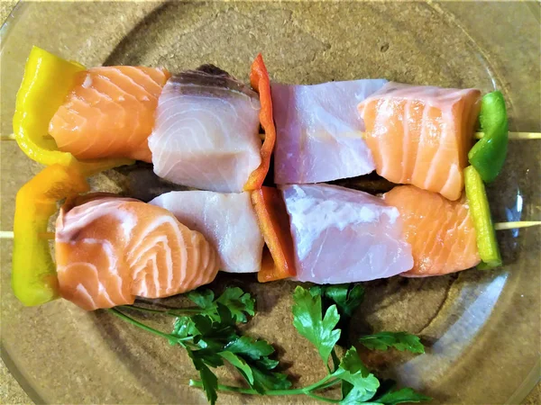 Izgara için ahşap çubuklar üzerinde çiğ somon parçaları.  