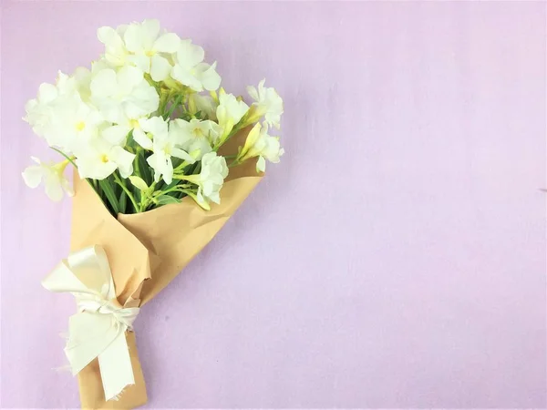 Bukett av vita blommor på violett bakgrund. — Stockfoto