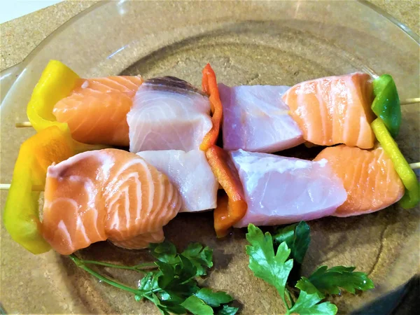 Izgara için ahşap çubuklar üzerinde çiğ somon parçaları. 