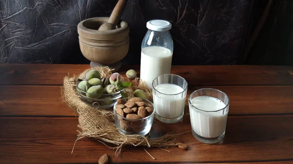 Almonds and fresh milk on wood background — Stock Photo, Image