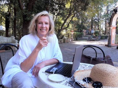 Dışarıda tablet bilgisayar kullanan güzel, son sınıf öğrencisi bir kadın.