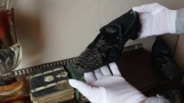 Nadir vintage ayakkabılar beyaz eldiven giyen kişi tarafından tutuluyor. Özel Müze, İtalya, Sicilya