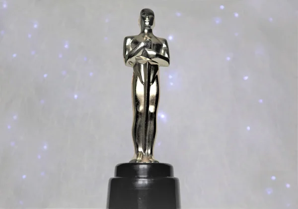 Beyaz bir arka plan üzerinde Oscar heykeli altın