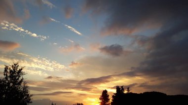siluetli ağaçlar ile güzel bulutlu günbatımı gökyüzü