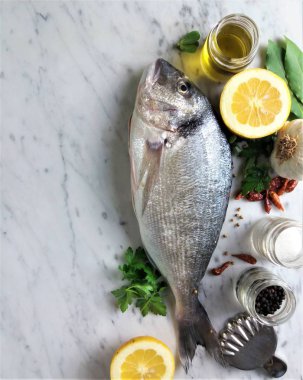 Limon ve tuz ve biber ile mermer bir arka plan üzerinde taze balık