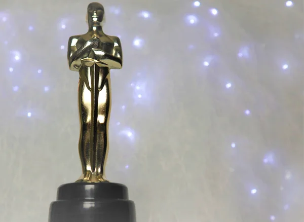 Beyaz bir arka plan üzerinde Oscar heykeli altın