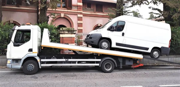 Şehir caddesinde bir çekici üzerinde kırık minibüs yükleme