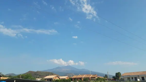 Malowniczy Widok Błękitne Niebo Nad Dachami Domów Zamontować Etna — Zdjęcie stockowe