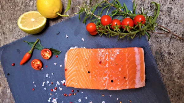 Raw salmon filet on dark slate background — Stock Photo, Image