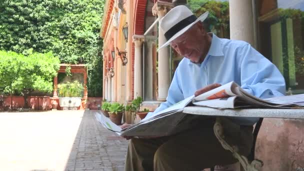 Den Äldre Läser Pressen Senior Man Reading Tidning När Sitter — Stockvideo