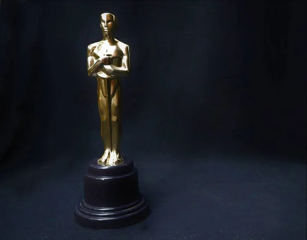 The golden statue of Oscar on a black background — Stock Photo, Image