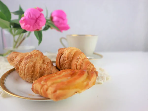 Breakfast with cup of coffee and croissants, bouquet of pink flo — Stock Photo, Image