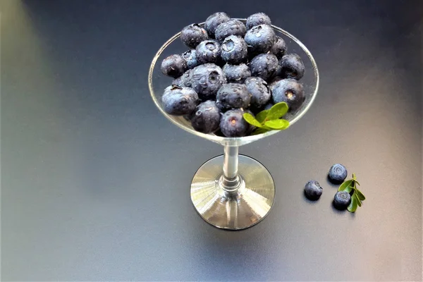 Fresh raw organic blueberries with leaf in in a glass wine glass — Stock Photo, Image