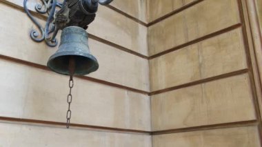 Yaşlı bir zili çalan kadının eli, evin duvarındaki eski zili çalıyor.