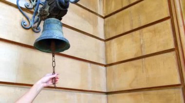 Yaşlı bir zili çalan kadının eli, evin duvarındaki eski zili çalıyor.