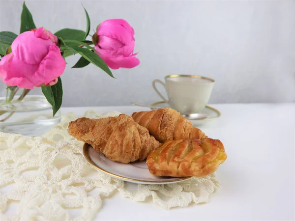 Breakfast with cup of coffee and croissants, bouquet of pink flo — Stock Photo, Image