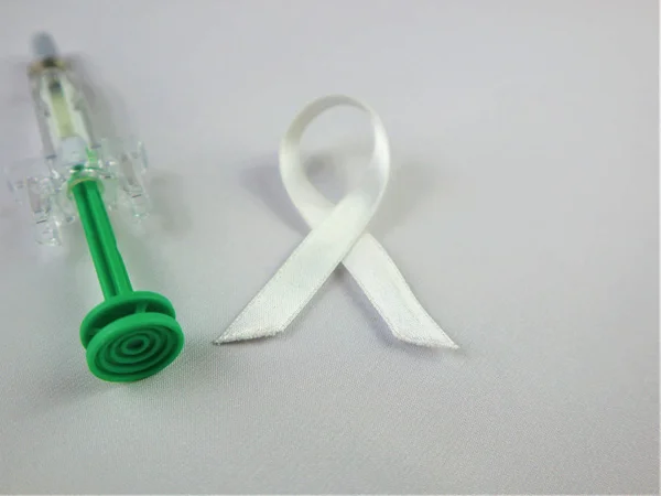 World Osteoporosis Day white ribbon bow, syringe . Medical conce — Stock Photo, Image