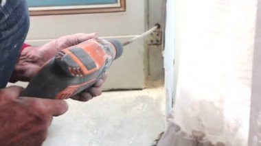 Yakın çekim, bir marangozun elleri duvar açıyor.