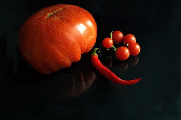big red tomato, cherry tomatoes and red chili pepper with copy s