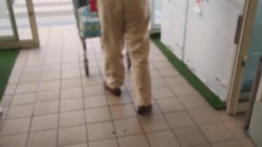 Yaşlı yaşlı yalnız adam alışveriş için bir süpermarkette araba ile geldi. bulanık arka plan. 