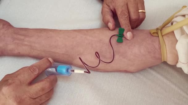 选择或服用静脉血的过程 桌子上的试管 针管的特写从一个人的手臂中抽血 一个人献血的人的手 男性献血者在流动献血中心献血 — 图库视频影像