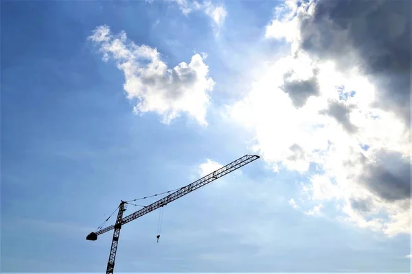 Costruzione gru torre contro un cielo blu, nuvole — Foto Stock