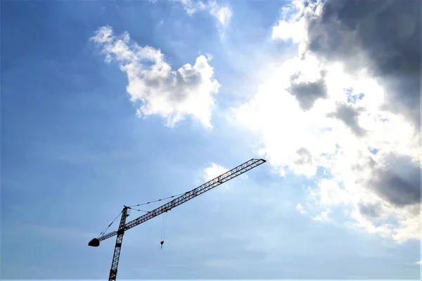 Mavi gökyüzüne karşı inşaat vinç kulesi, bulutlar — Stok fotoğraf