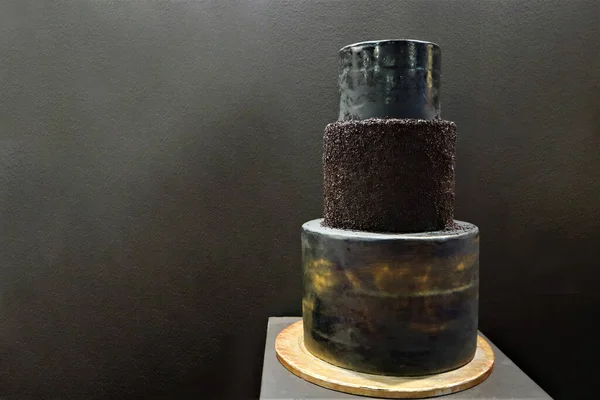 Black wedding cake. Big wedding cake. Decor trends. Wedding ceremony. On the black background.