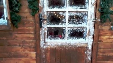 Noel kompozisyonu. Ahşap bir evin buzlu pencerelerinden görünen Noel şöminesi.