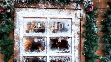 Noel kompozisyonu. Ahşap bir evin buzlu pencerelerinden görünen Noel şöminesi.