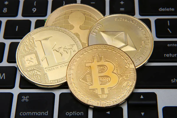 Litecoin, Onda, Ethereum & Bitcoin monedas de oro que representan criptomonedas contra un ordenador portátil teclado de fondo . — Foto de Stock