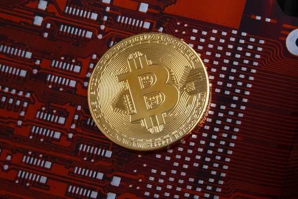 Bitcoin moneda de oro en un circuito flexible ordenador naranja o rojo y negro . — Foto de Stock