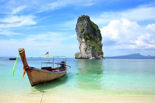 Um barco de pesca tailandês amarrado na praia com uma bela ilha ao fundo, Krabi, Tailândia . — Fotografia de Stock