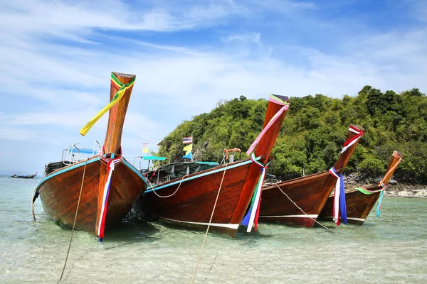 Ταϊλάνδης ψαρόβαρκες δεμένο στην παραλία με ένα πανέμορφο νησί στο παρασκήνιο, Krabi, Ταϊλάνδη. — Φωτογραφία Αρχείου