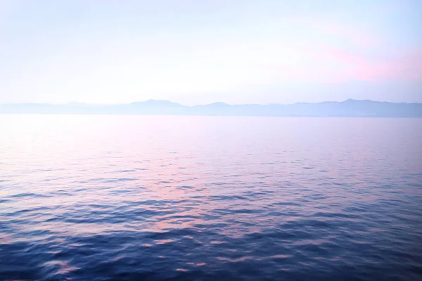 Vista do pôr do sol sobre o oceano calmo olhando para o horizonte . — Fotografia de Stock