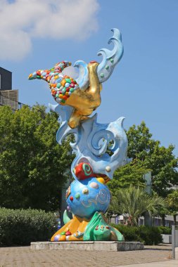 Şehir merkezinde, arka planda binalar bulunan modern bir sanat denizkızı heykeli, Saint Nazaire şehir merkezi, Loire Atlantique, Fransa.