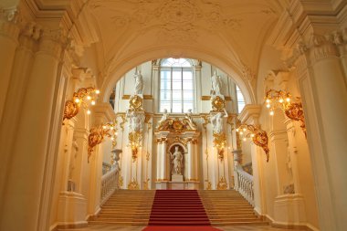 Altın ve kırmızı halıyla dekore edilmiş güzel bir iç mekan. Kış Sarayı 'nın Ürdün Merdiveninin alt kısmı, Eyalet Hermitage Müzesi, St Petersburg, Rusya.