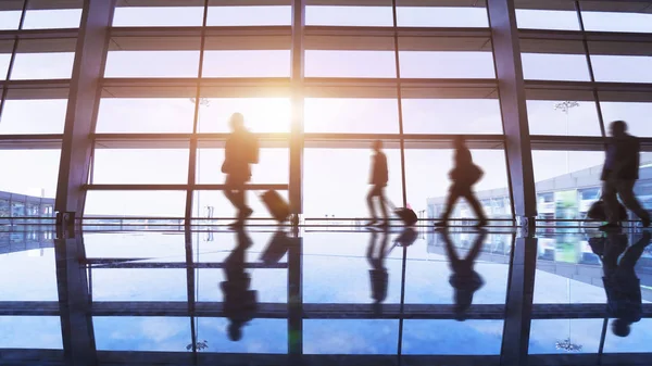 Busy airport terminal, walking passengers