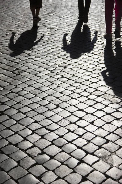 Bir kaldırım taşı kaldırım üzerinde insanların net gölgeler