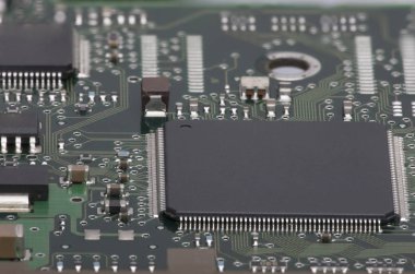 Elektronik pano. Yönetim Kurulu öğeleri özellikleri: cips, diyotlar, kapasitörler, bobinleri. Sığ derinlik-in tarla. Arka plan olarak kullanılabilir. Bir yazıt için bir yer var..