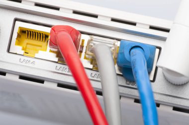 Kablosunun bağlanması ile modem yönlendirici ağ hub'u. Parlak mavi ve kırmızı kablolar ve konektörler.