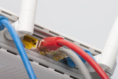 Kablosunun bağlanması ile modem yönlendirici ağ hub'u. Parlak mavi ve kırmızı kablolar ve konektörler.
