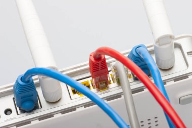 Kablosunun bağlanması ile modem yönlendirici ağ hub'u. Parlak mavi ve kırmızı kablolar ve konektörler.