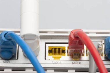 Kablosunun bağlanması ile modem yönlendirici ağ hub'u. Parlak mavi ve kırmızı kablolar ve konektörler.