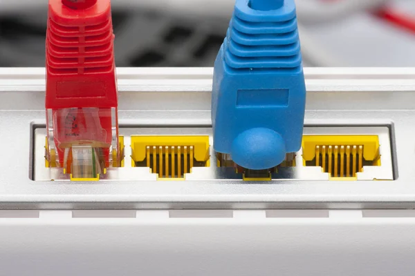 Modem router network hub with cable connecting. Bright blue and red cables and connectors.