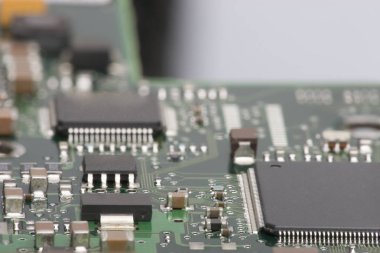 Elektronik pano. Yönetim Kurulu öğeleri özellikleri: cips, diyotlar, kapasitörler, bobinleri. Sığ derinlik-in tarla. Arka plan olarak kullanılabilir. Bir yazıt için bir yer var..