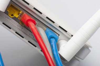 Kablosunun bağlanması ile modem yönlendirici ağ hub'u. Parlak mavi ve kırmızı kablolar ve konektörler.
